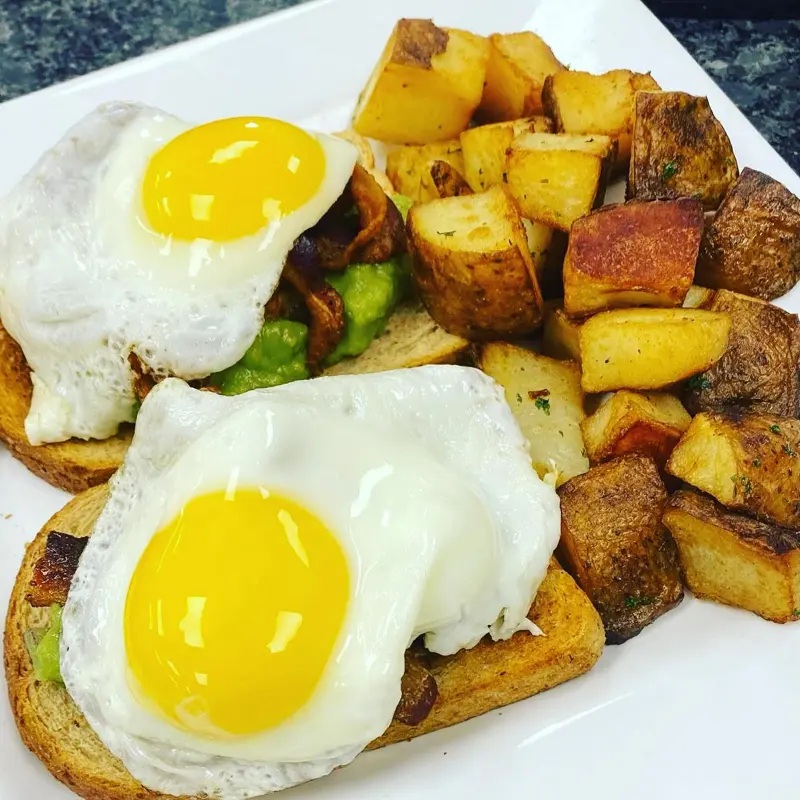 Avocado toast with fried eggs and home fries